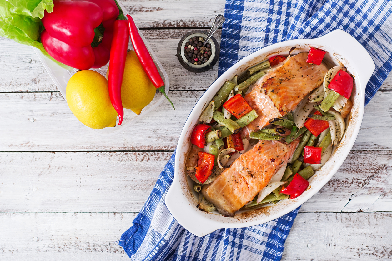 Baked salmon fillet with vegetables and herbs. Top view