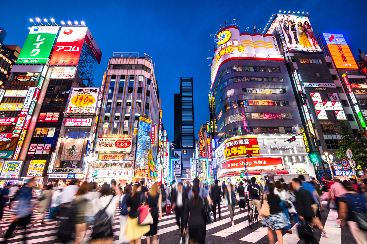Crowded streets of Shinjuku shopping district with blurred commuters at dusk