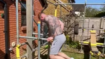 Man bouwt leipe thuis gym van steigers zodat hij kan blijven sporten